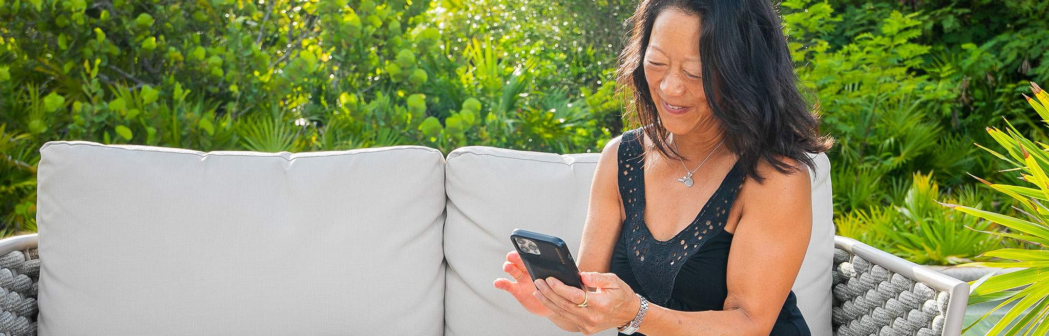 woman on patio couch on her cellphone