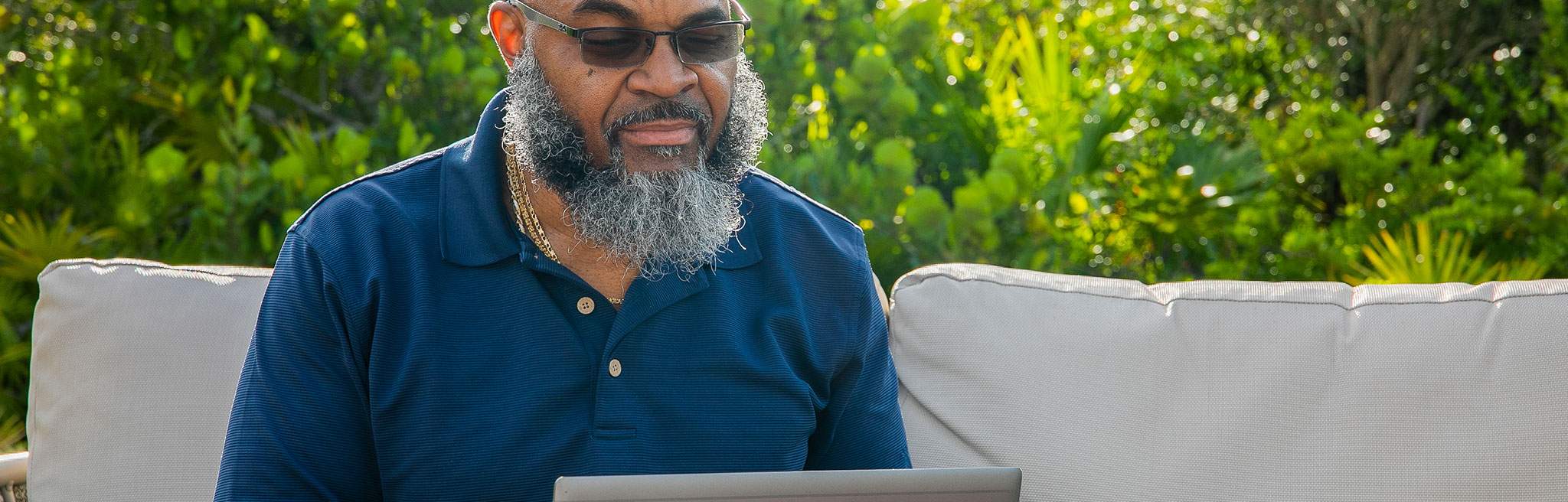man with sunglasses using a laptop